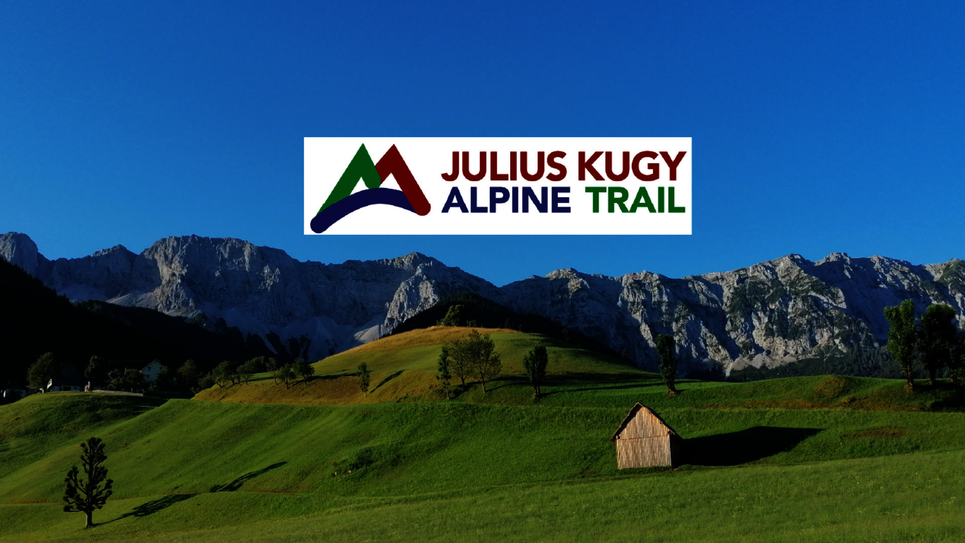 <p>Berglandschaft der Koschutta Kette mit Logo des Julius Kugy Alpine Trail.</p>