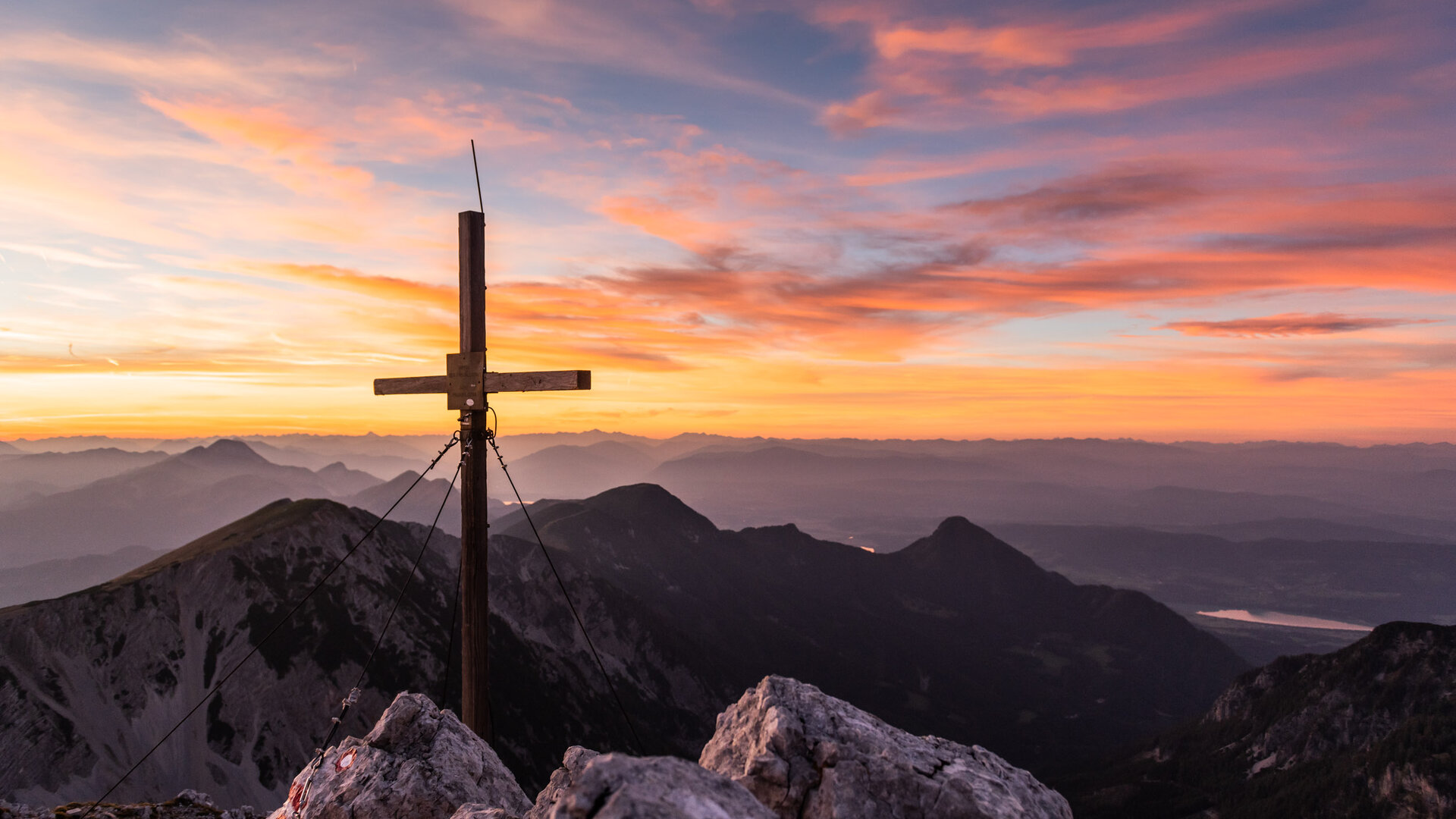 <p>Sonnenaufgang hinter einem Gipfelkreuz in den Karawanken im Kärntner Rosental.</p>